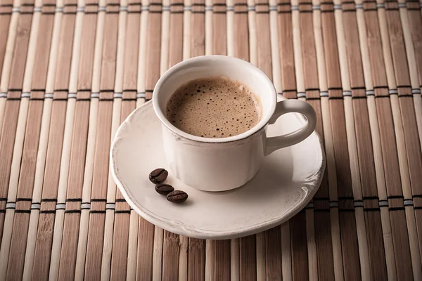 Verse koffie en koffiebonen op een tafel — Stockfoto