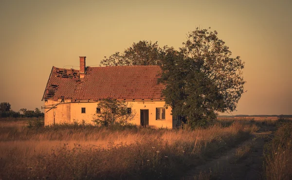 Vintage photo of abandoned house in sunset — Stock Photo, Image