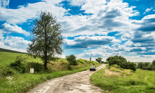 Vecchia auto nella strada di campagna — Foto Stock