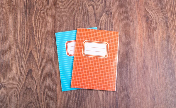 Two colored exercise books on the wooden table — Stock Photo, Image