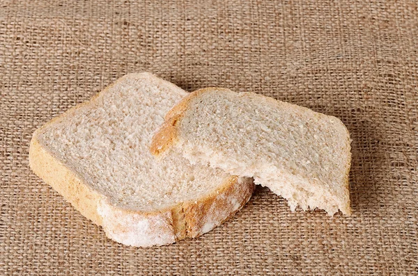 Sliced bread on sackcloth — Stock Photo, Image