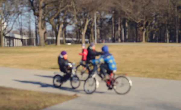 Blurred photo of cycling children in park — Stock Photo, Image