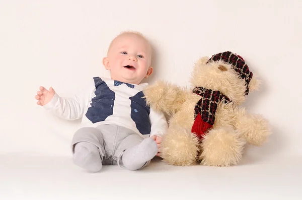 Adorable bebé sobre fondo blanco con su amigo — Foto de Stock