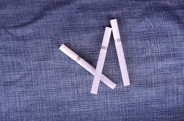 Foto de close-up de cigarros em um fundo de jeans — Fotografia de Stock