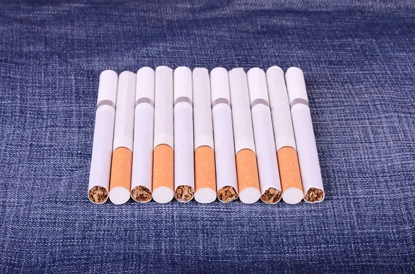 Foto de close-up de cigarros em um fundo de jeans — Fotografia de Stock