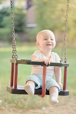Erkek eğleniyor bir salıncak binen bir bahçesi mutlu bebek