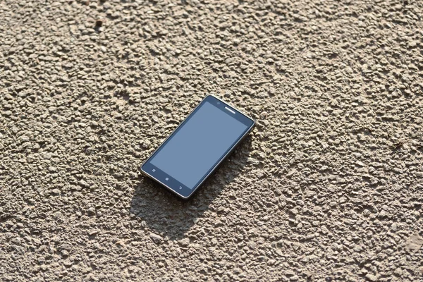 Lost cellphone on asphalt — Stock Photo, Image