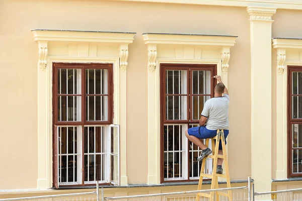 Worker painting  the window — Stock Photo, Image