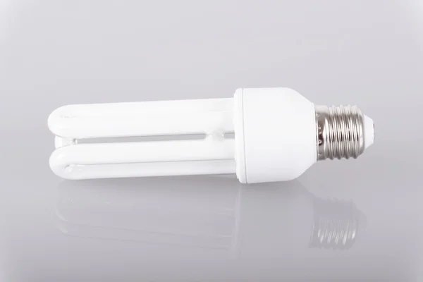 Energy efficient light bulb on gray background — Stock Photo, Image