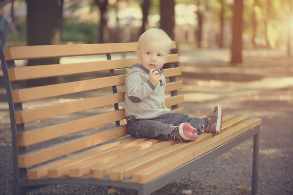 Adorable baby sitting on the bench — Stock Photo, Image