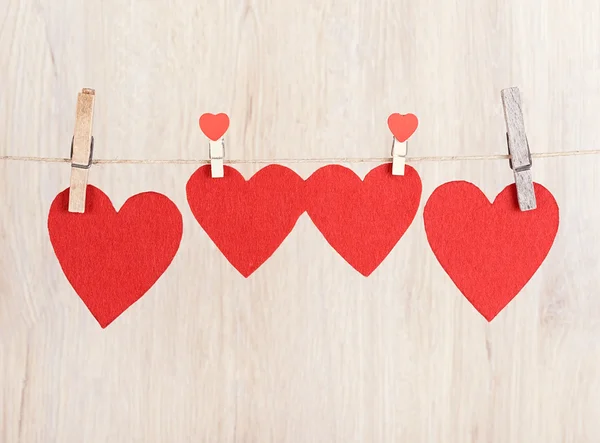 Fyra röda hjärtan hängde på repet — Stockfoto