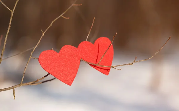 Red heart shapes on snow — Stock Photo, Image