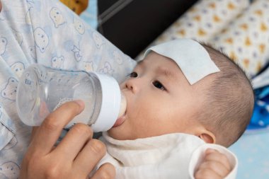 Anne, yüksek ateşi olan 4 aylık bebek sütüyle besleniyor.