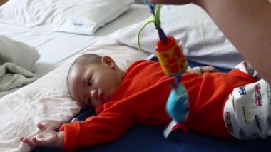 Küçük bebek hastalanıyor ve hastane koğuşunda ağlıyor.