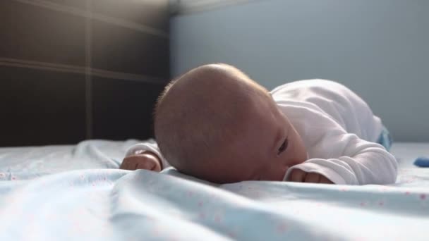 アジア系中国人の男の子のベッドの上でおなかの時間を行う横たわっ 4Kライフスタイルフッテージの可愛い赤ちゃん男の子の5ヶ月赤ちゃん — ストック動画