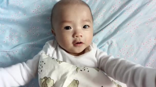4Kライフスタイルかわいい赤ちゃんの笑顔とカメラを閉じて見ての映像 赤ちゃん 子供時代 産前産後の概念 — ストック動画