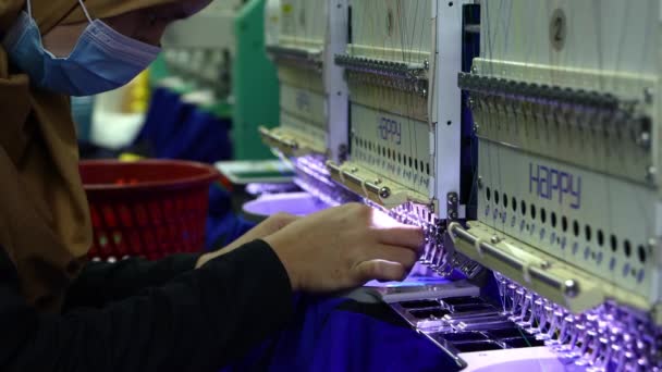 マレーシア サバ州コタキナバル2020年12月15日 4K映像クローズアップ作業員が縫製工場の繊維産業で高速回転する刺繍機の針に糸をかける — ストック動画