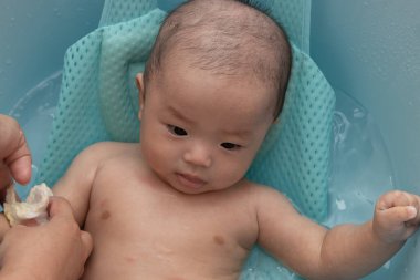 Asyalı mutlu bir Çinli çocuğun banyo yaparken portresi.