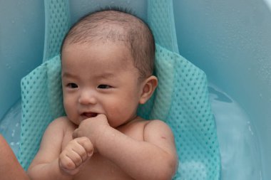 Asyalı mutlu bir Çinli çocuğun banyo yaparken portresi.