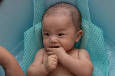 Asyalı mutlu bir Çinli çocuğun banyo yaparken portresi.
