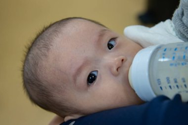 Asyalı bebek sütü şişeden içer, süt zamanı, yatağa git.