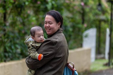Doğa yağmur ormanlarında mutlu anne ve bebek kucaklaşması. Açık havada mutlu bir aile..
