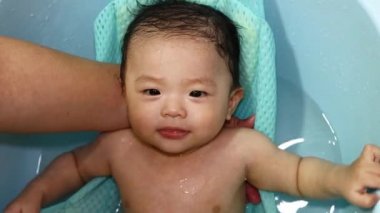 Mutlu ve tapılası erkek bebek banyo yaparken suyla oynuyor.