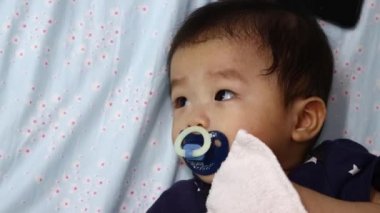 8 aylık Çinli bebek emziğin yerel yaşam tarzı uyumaya hazır.