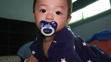 8 aylık Çinli bebek emziğin yerel yaşam tarzı uyumaya hazır.