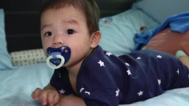 8 aylık Çinli bebek emziğin yerel yaşam tarzı uyumaya hazır.