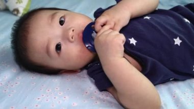 8 aylık Çinli bir çocuğun emziğinin etrafında oynaması.