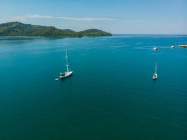 Kuala Abai, Kota Belud, Sabah, Malezya 'da güzel manzara manzaralı derin mavi denizde beyaz bir yat manzarası.