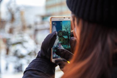 Sapporo, Hokkaido, Japonya - 26 Aralık 2017: Tanımlanamayan Genç Asya Turist Kız Japonya 'nın Hokkaido kentindeki Sapporo şehrinde kış sezonunda akıllı telefon kullanarak fotoğraf çekiyor