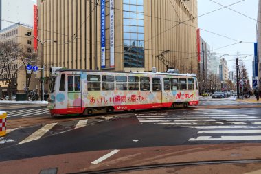 SAPPORO, JAPONYA-26 Aralık 2017: Japonya 'nın Hokkaido kentindeki Sapporo City' de kış sezonunda sokaktaki en ünlü tramvay tramvayı