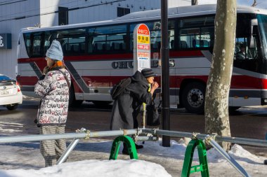 Otaru, Japonya - 25 Aralık 2017: Otaru Şehri, Hokkaido Japonya 'da kış mevsiminde kimliği belirsiz yayalar otaru kentinde yürüyor ve yol karla kaplanıyor.