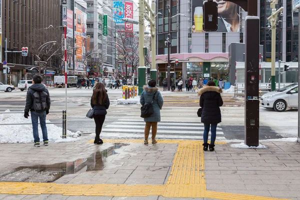 日本札幌 2017年12月25日 在日本北海道札幌市 身份不明的行人在冬季穿着冬季夹克和道路被雪覆盖 — 图库照片