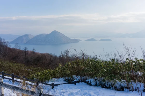 Güzel kış manzarası, kar altında kış ormanı, ayak izleriyle, yol üzerinde toz kar, Hokkaido Japonya