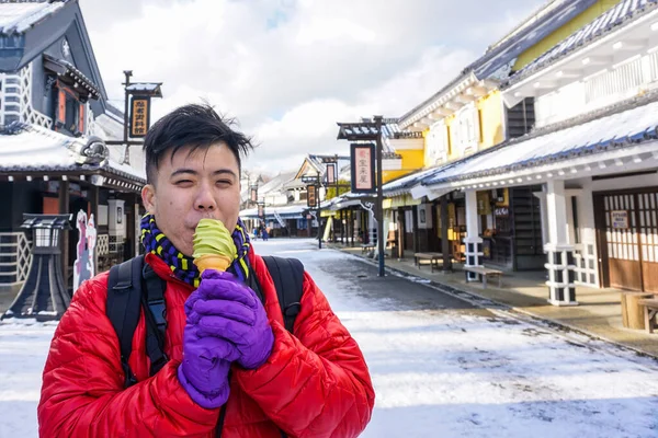 An Asian Chinese guy having a Mocha ice cream at Hokkaido, Japan - Holiday Concept