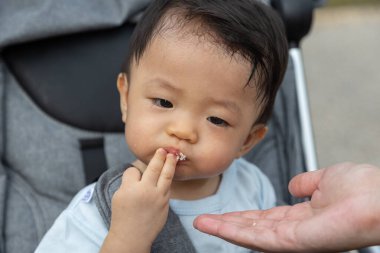 Akşam saatlerinde parkta bebek arabasında oturan mutlu ve şirin Asyalı Çinli bebeğin yakın plan portresi.