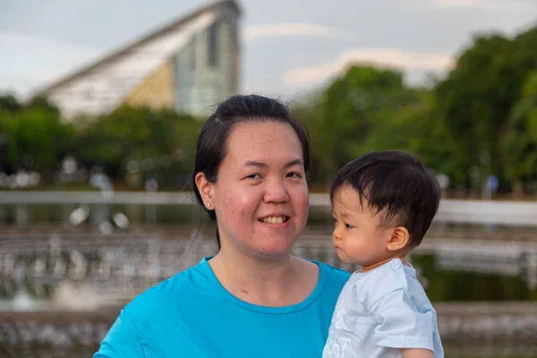 Šťastná Čínská Matka Nést Rok Starý Chlapeček Parku — Stock fotografie