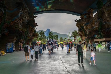 Zhuhai, Çin - 12 Mayıs 2025: Turistler Çin 'in Zhuhai kentinde Hengqin' de bir eğlence parkı olan Chimelong Okyanus Krallığı 'nın girişine doğru yürüyorlar.