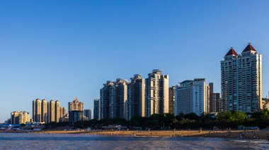 Zhuhai, Guangdong, Çin - 14 Mayıs 2025: Arka planda Zhuhai kentinin yer aldığı, günbatımında dolambaçlı bir kıyı yolunun manzarası