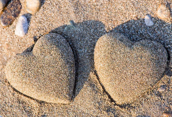Dwa serca piasek kształt w piasku nad morzem — Zdjęcie stockowe