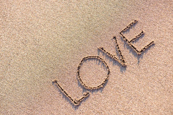 砂の背景に単語「愛」 — ストック写真