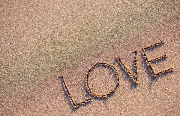 Wort "Liebe" auf Sandgrund — Stockfoto