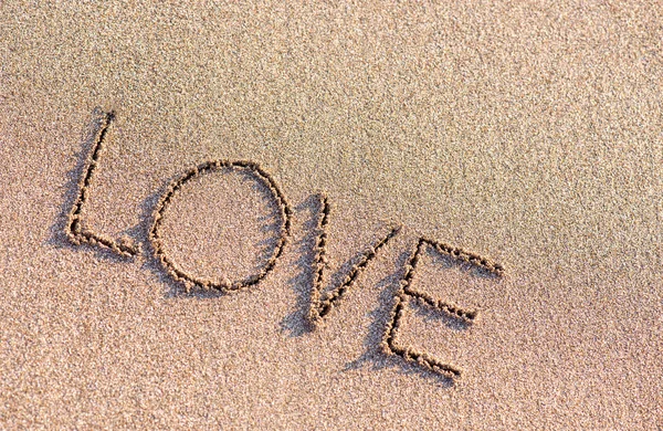 Słowo "miłość" na tle piasek — Zdjęcie stockowe