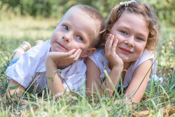 Malý chlapec a dívka leží trávě — Stock fotografie