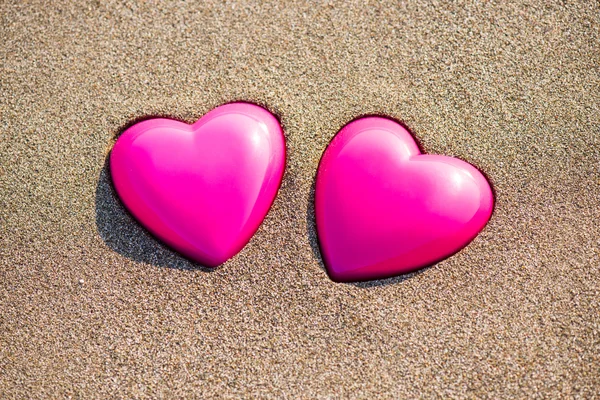 Dwa czerwone serca na plaży symbolizującym miłość — Zdjęcie stockowe