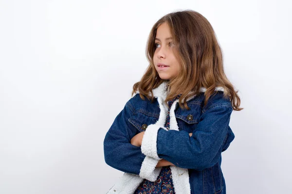 小さなCaucasian女の子とともに美しいです青目身に着けているデニムジャケットスタンド上の隔離された白い背景クロス手見てコピースペース — ストック写真