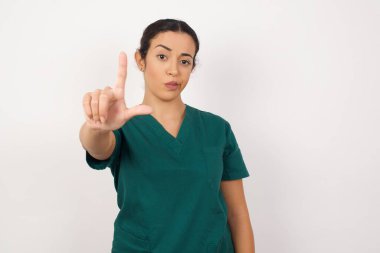 Güzel, genç bir hemşire parmakları alnında insanlarla dalga geçiyor ezikçe davranışlar sergiliyor, alay ediyor..